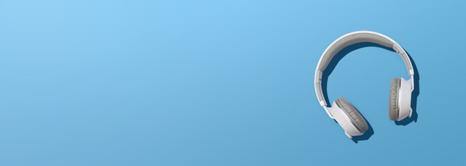 Headphones on blue background. Front view photo. White wireless headphones