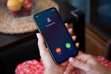 female hands in red dress holding phone with incoming call