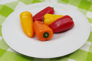 Small sweet peppers on a white plate. Paprika