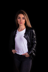 A young girl in a black leather jacket isolated on a black background