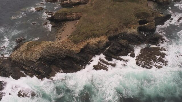 Beautiful Coastline view and waves crashing on rocky cliff shoreline. Aerial Drone Video