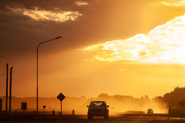 Fototapeta na wymiar Fast car in dusty sunset