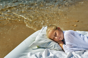 Sleeping little girl in nature . The child is resting at a seaside resort . The concept of healthy sleep .