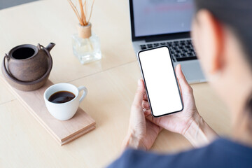cell phone mockup image blank white screen.woman hand holding texting using mobile on desk at coffee shop.background empty space for advertise.work people contact marketing business,technology