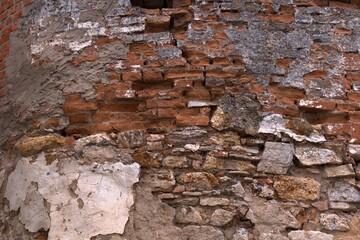 fragment of the wall of the old castle made of cobblestone, granite and red brick