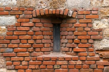 narrow window in brick wall of old fortress