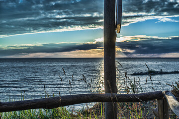 picturesque view of endless seascape with sunbeams reflecting on mirror water surface at cloudy day