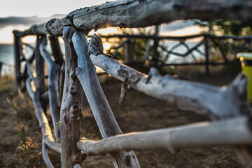 rustic wooden fence on shore of river at sunny day 