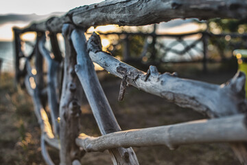 rustic wooden fence on shore of river at sunny day 