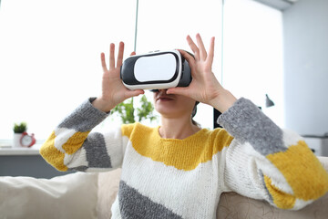 Woman hold and look video in virtual reality glasses. Virtual reality object transmitted to person...