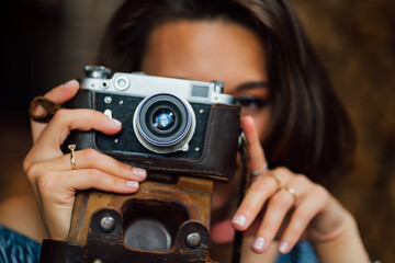 close-up of beautiful brunette girl  with retro camera in hands.