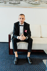 Portraits of the groom at the hotel training camp, dressed as a businessman in a black suit, tuxedo and white shirt