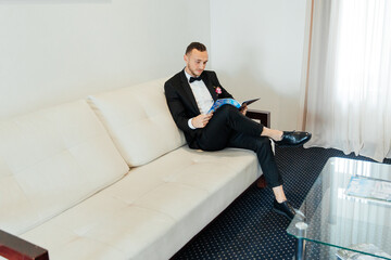 Portraits of the groom at the hotel training camp, dressed as a businessman in a black suit, tuxedo and white shirt