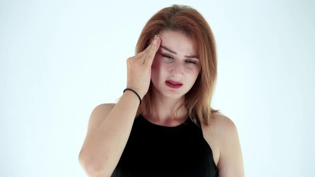 Portrait of stressed attractive young woman having terrible strong headache isolated on white background. Studio shot. Concept of headaches, migraines, diseases.