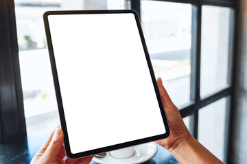 Mockup image of a woman holding black tablet pc with blank white desktop screen