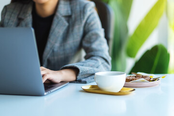 Closeup image of a business woman using and working on laptop computer in office
