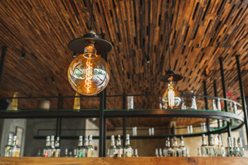 Creativity designed round shape electric bulb lamp in restaurant interior decor. Cafe bar blurred background.