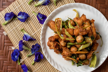 Fried crispy fish with bell pepper on the wood board.