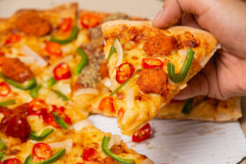 Pizza party. Hand picking slice of pizza.