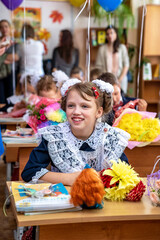 schoolgirl sits at a Desk at school on September 1. Holiday of knowledge.