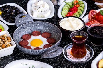 Traditional Turkish Breakfast with sausage egg pan on granite marble table.Close and large view         