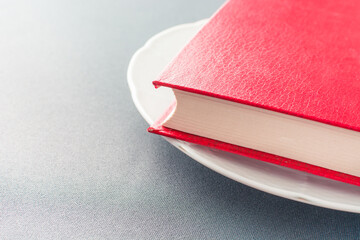 Beautiful red book lies on a white plate