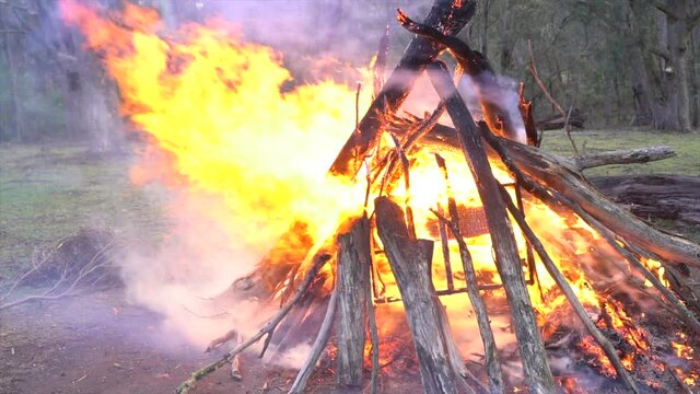 Large campfire/ bonfire on outback farm in Australia, keeping warm camping in winter in the snow