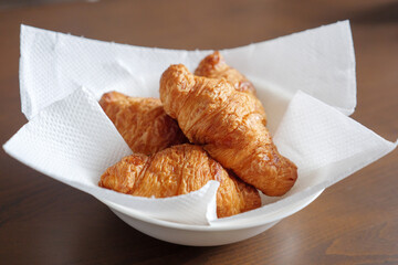 キッチンペーパを敷いた皿に置いた光沢のあるクロワッサン