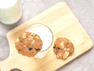 Healthy homemade oat cookies put on glass milk over wooden plate. Top view with copy space..