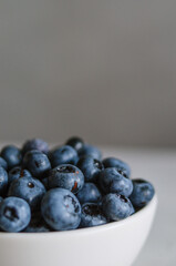 Dark macro of fresh blueberry in ivory bowl. Concept for healthy eating and nutrition. Antioxidant organic superfood