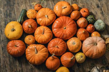 Beautiful pumpkins for Halloween lie on the wooden floor. Pattern.