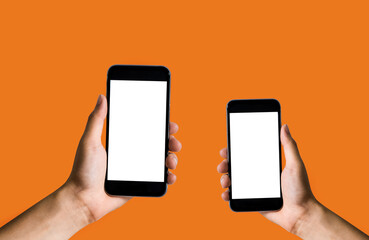 Female hand holding the black smartphone with blank screen and modern frameless design two positions angled and vertical - isolated on orange background.
