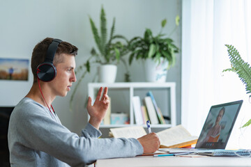 A College student uses a laptop, answers the lesson remotely. E-learning.