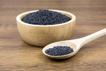 Black sesame seeds in a wooden spoon For healthy food and diet concepts.