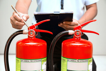 Fire fighter are checking fire extinguishers tank in the building concepts of fire prevention...