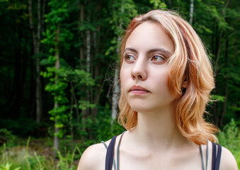 Fototapeta premium portrait of a young beautiful blonde girl in the park