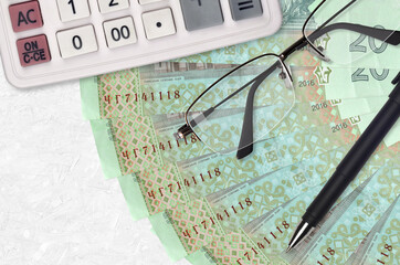 20 Ukrainian hryvnias bills fan and calculator with glasses and pen. Business loan or tax payment...