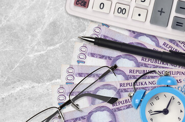 100 Philippine piso bills and calculator with glasses and pen. Business loan or tax payment season...