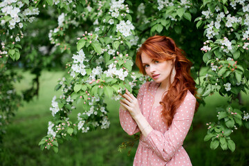 Russian redheaded pretty girl in apple trees