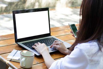 Fototapeta premium Business concept : Back view of business woman hands busy using laptop at cafe, Young woman working on his laptop with blank copy space screen for your advertising text message in cafe.