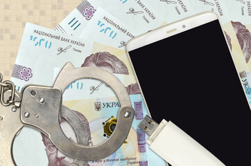 1000 Ukrainian hryvnias bills and smartphone with police handcuffs. Concept of hackers phishing...