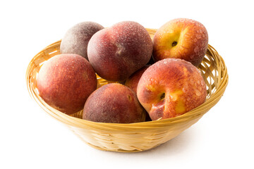 Fresh peaches in basket on white