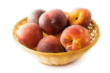 Fresh peaches in basket on white