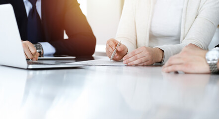 Business people discussing contract while working together in sunny modern office. Unknown...
