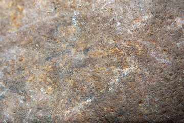 Macro shooting of smooth stone surface with blurred background. Background with fine cobblestone texture.