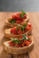 bruschetta with cherry tomatoes and spinach leaves on olive board