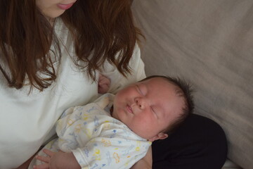 ママに抱かれて眠る生後36日の赤ちゃん
