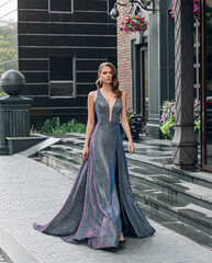 Beautiful young fashion gorgeous woman walks, modern black building, granite steps. Brunette girl...