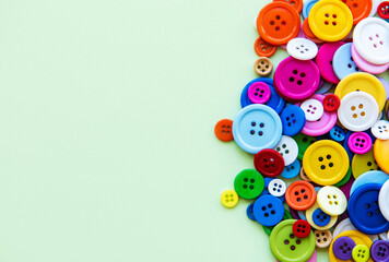 Sewing buttons on green pastel background