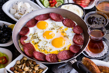 Traditional Turkish Breakfast with sausage egg pan on granite marble table.Close and large view          